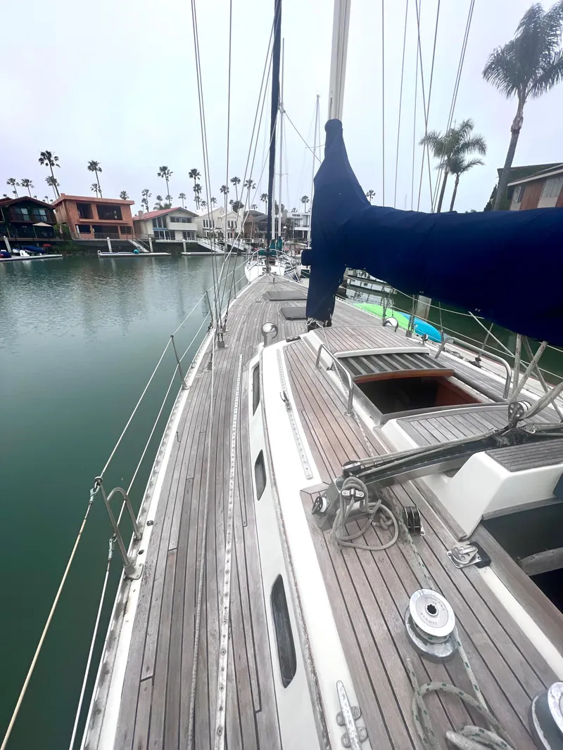 Slide: The Image of 1980 Lafitte 44 sailboat docked in a marina with palm trees. - 10