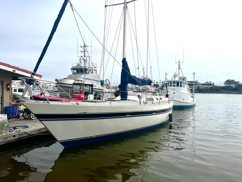 Slide: The Image of 1980 Lafitte 44 sailboat docked in a marina, surrounded by other boats. - 2