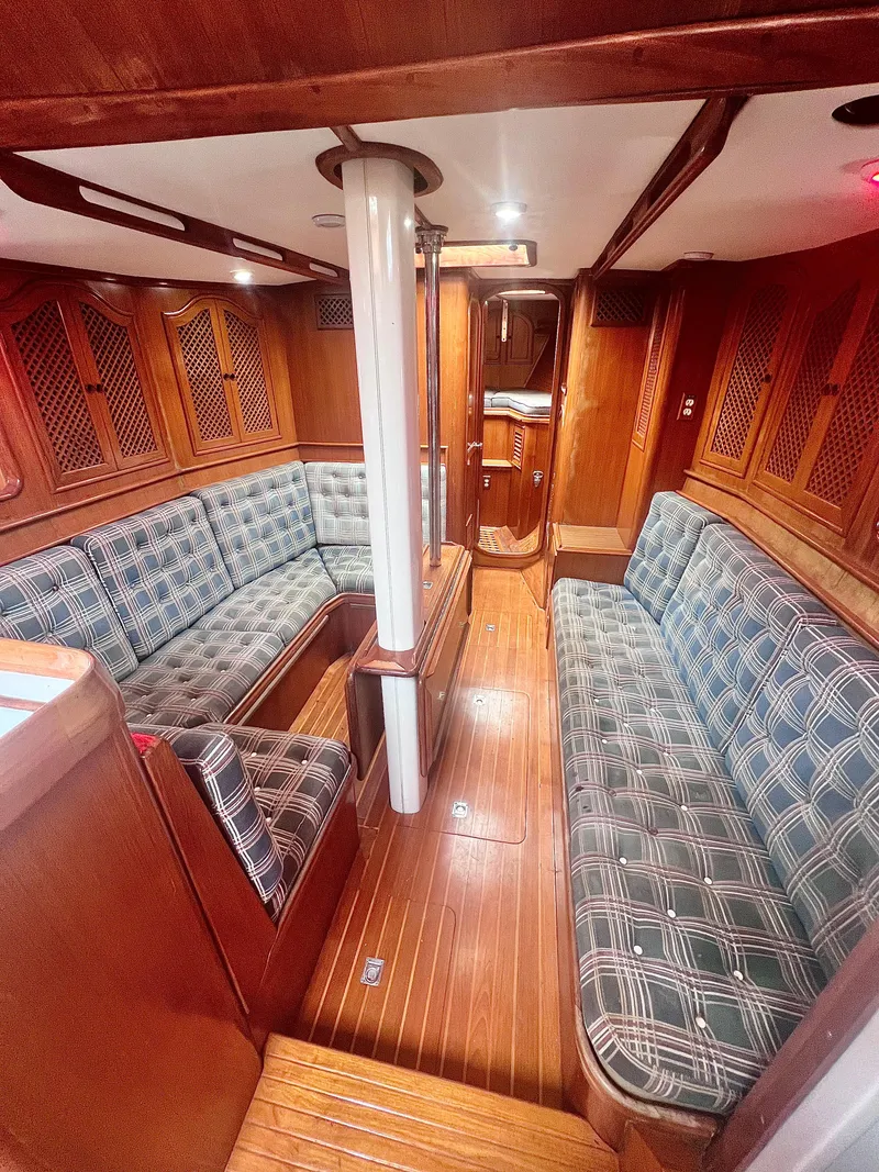 Slide: The Image of Interior of 1980 Lafitte 44 sailboat with wooden finish and plaid seating. - 25
