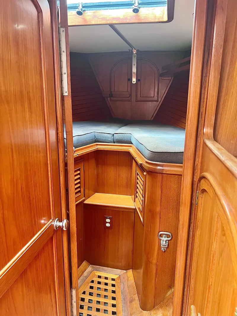 Slide: The Image of 1980 Lafitte 44 sailboat interior with wooden cabinetry and cozy sleeping area. - 26