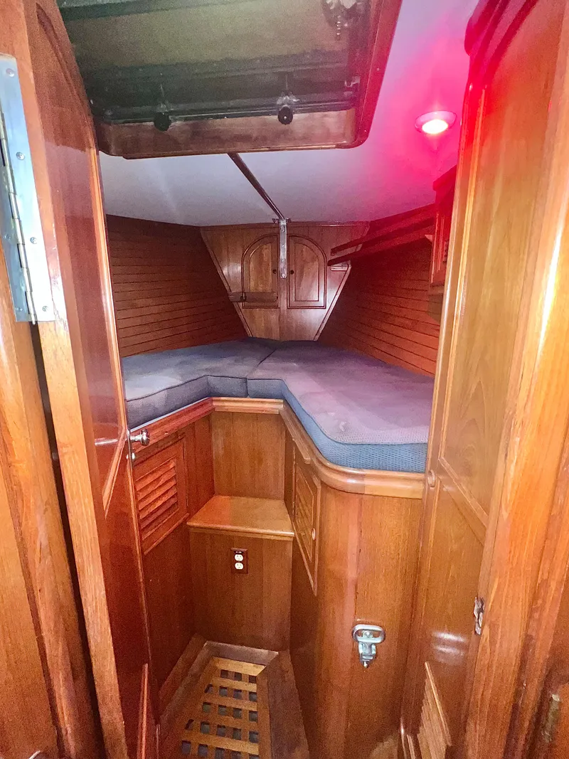 Slide: The Image of 1980 Lafitte 44 yacht interior with wooden cabinetry and cozy sleeping area. - 27