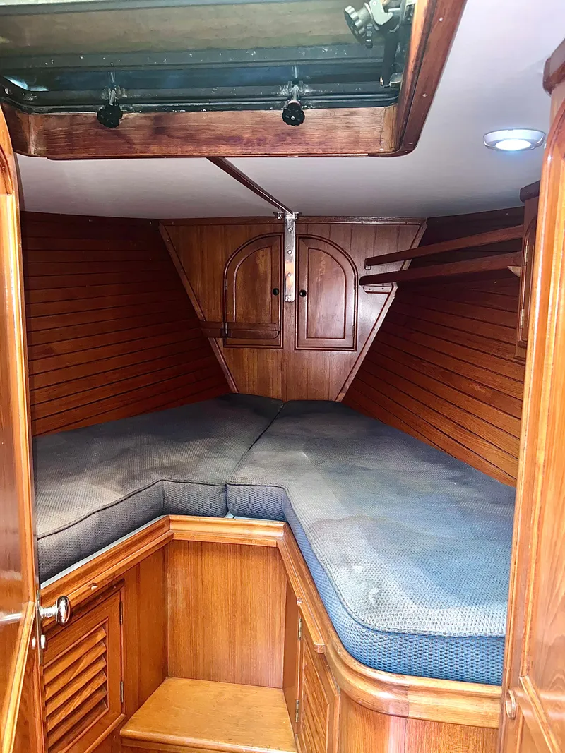 Slide: The Image of 1980 Lafitte 44 sailboat cabin with wooden interior and cushioned berth. - 28