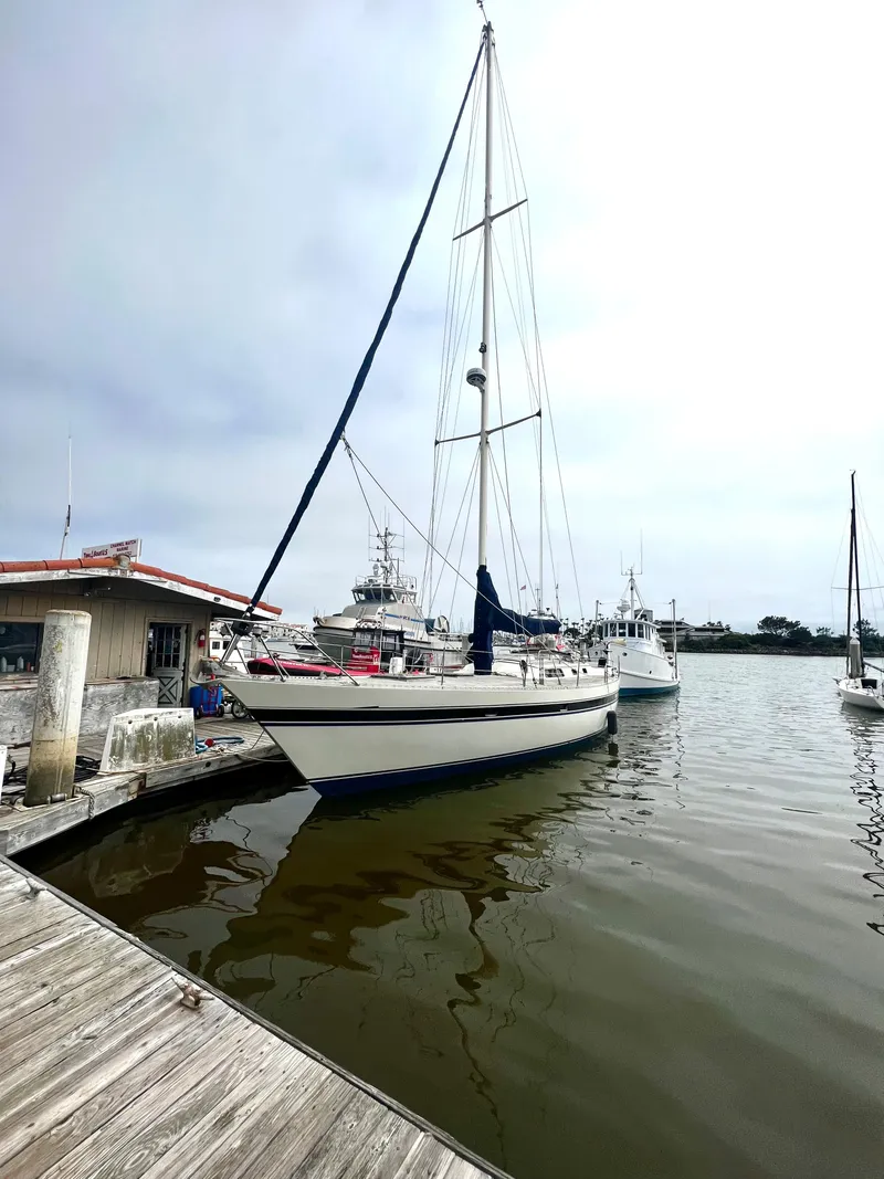 Slide: The Image of 1980 Lafitte 44 sailboat docked at marina, overcast sky, calm water. - 3