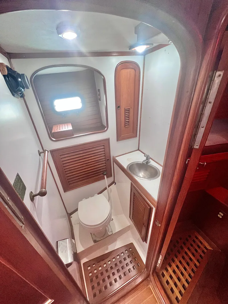 Slide: The Image of 1980 Lafitte 44 yacht bathroom with wooden accents and compact design. - 32