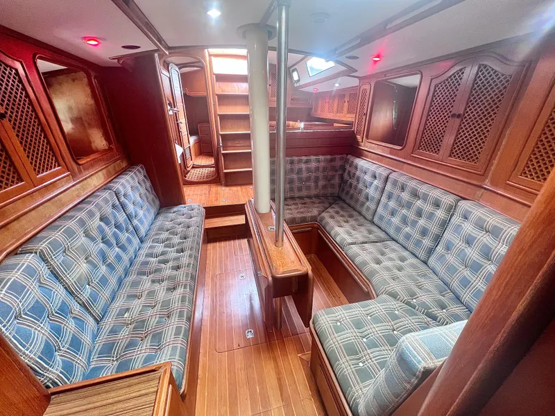 Slide: The Image of Interior of a 1980 Lafitte 44 sailboat with wooden finishes and plaid seating. - 33
