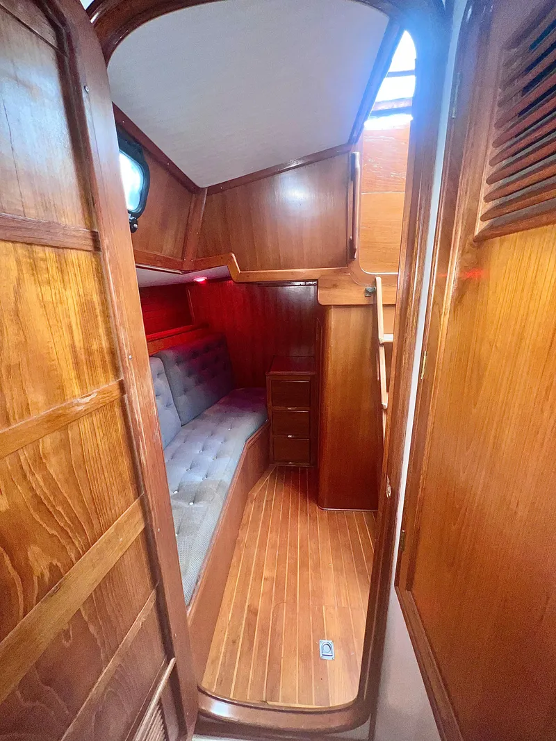Slide: The Image of 1980 Lafitte 44 yacht interior with wooden paneling and cozy seating area. - 35