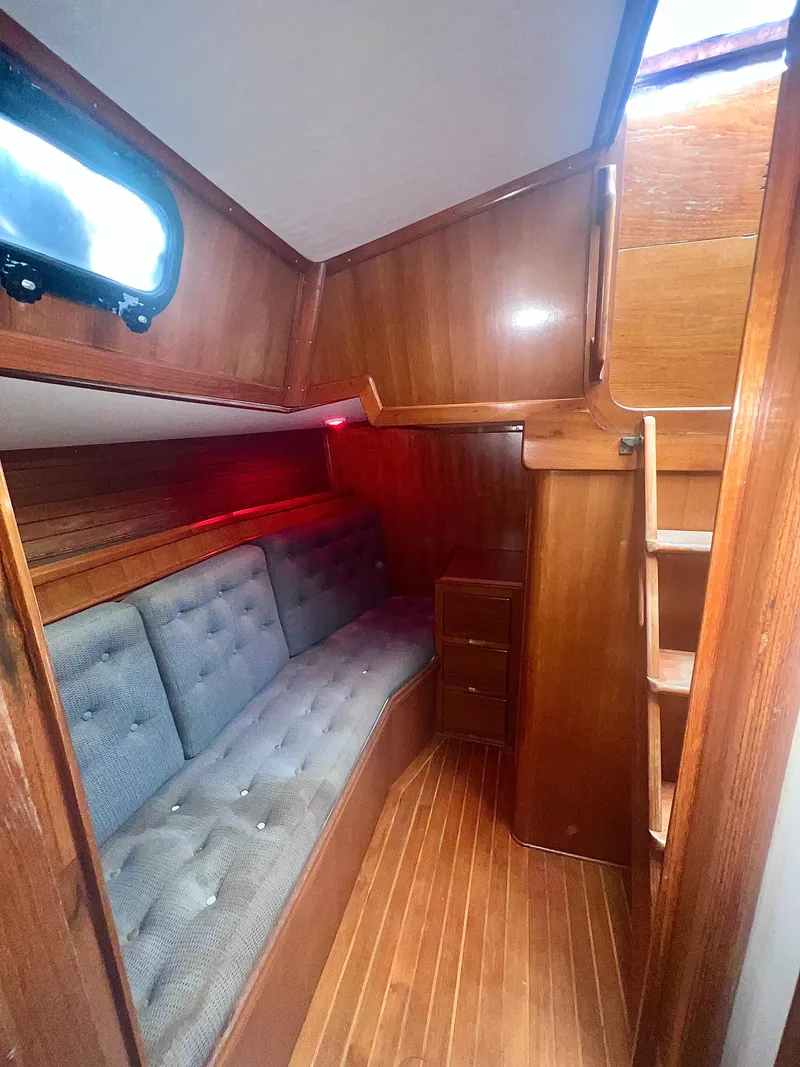 Slide: The Image of Interior of 1980 Lafitte 44 sailboat with wooden paneling and cushioned seating. - 36