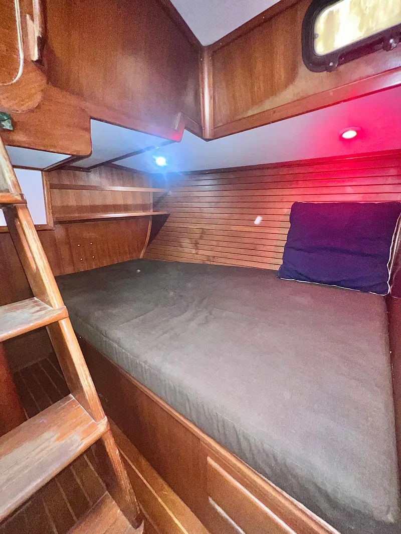 Slide: The Image of Cozy cabin interior of 1980 Lafitte 44 sailboat with wooden finish and ambient lighting. - 39