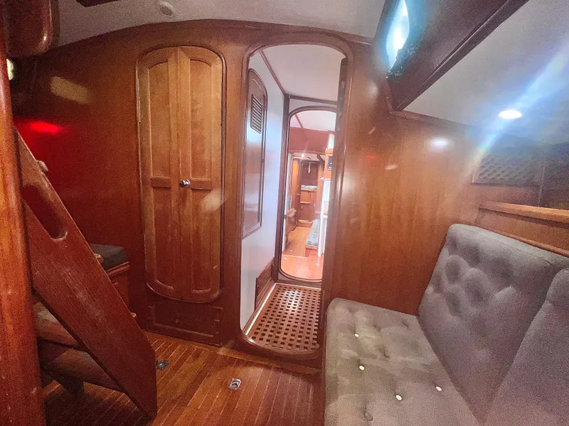 Slide: The Image of Interior of a 1980 Lafitte 44 sailboat with wooden paneling and seating area. - 40