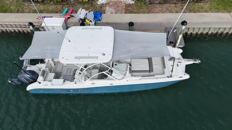 Slide: The Image of 2019 World Cat 255 DC boat docked at marina under clear blue sky. - 12