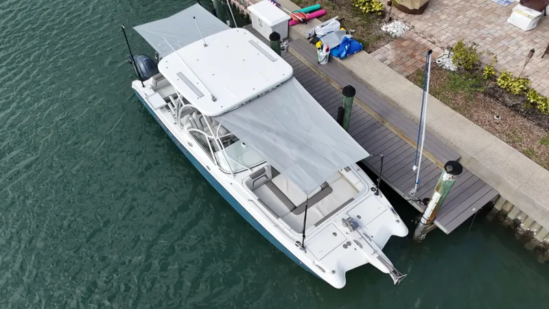 Slide: The Image of 2019 World Cat 255 DC boat docked in a marina under clear blue skies. - 13