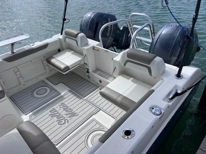 Slide: The Image of 2019 World Cat 255 DC boat interior with gray seating and open storage compartments. - 16