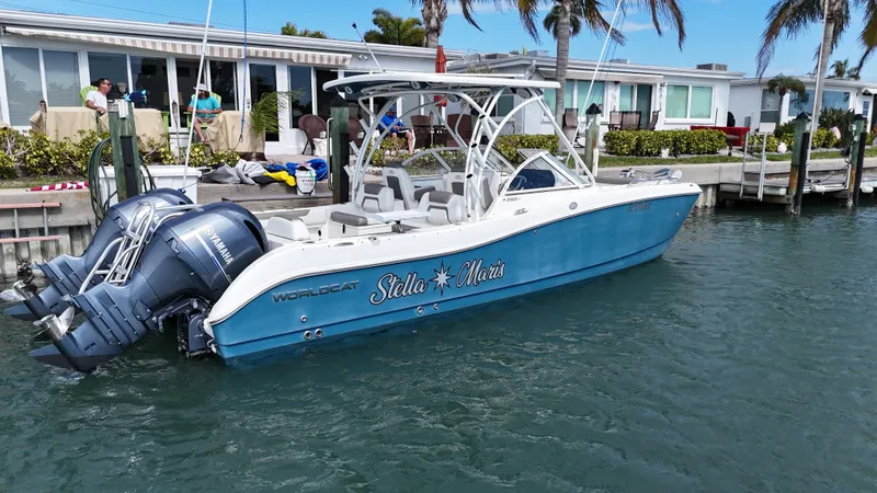 Slide: The Image of 2019 World Cat 255 DC boat cruising on clear blue water with two passengers. - 2