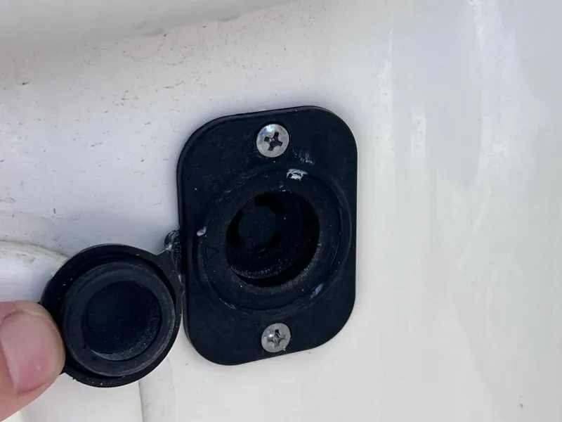 Slide: The Image of 2019 World Cat 255 DC boat interior with seating and table, docked by the water. - 24