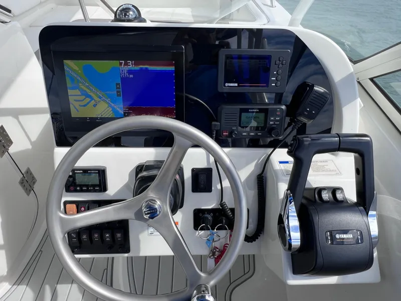 Slide: The Image of 2019 World Cat 255 DC boat interior with seating, docked by waterfront homes. - 52