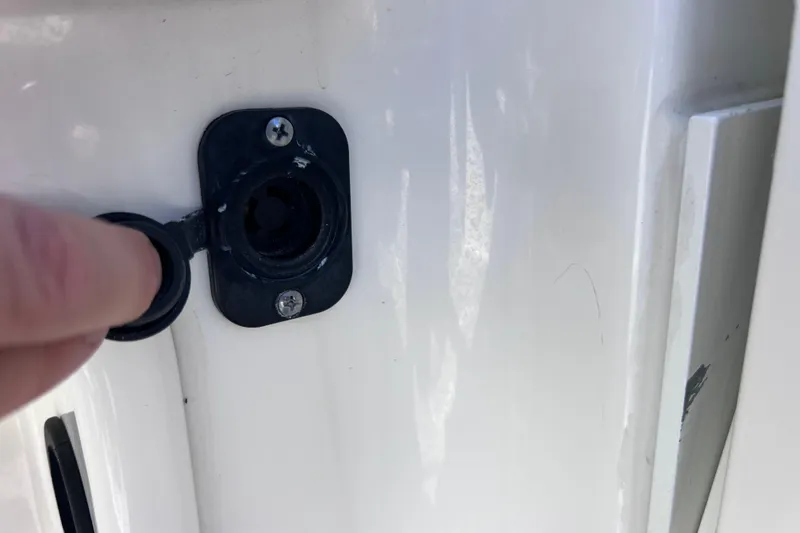 Slide: The Image of Close-up of a 2019 World Cat 255 DC boat's plug socket with a finger touching it. - 76