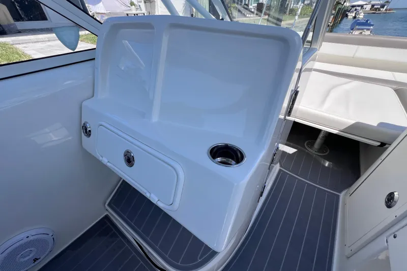 Slide: The Image of 2019 World Cat 255 DC boat interior with storage compartment and cup holder. - 79