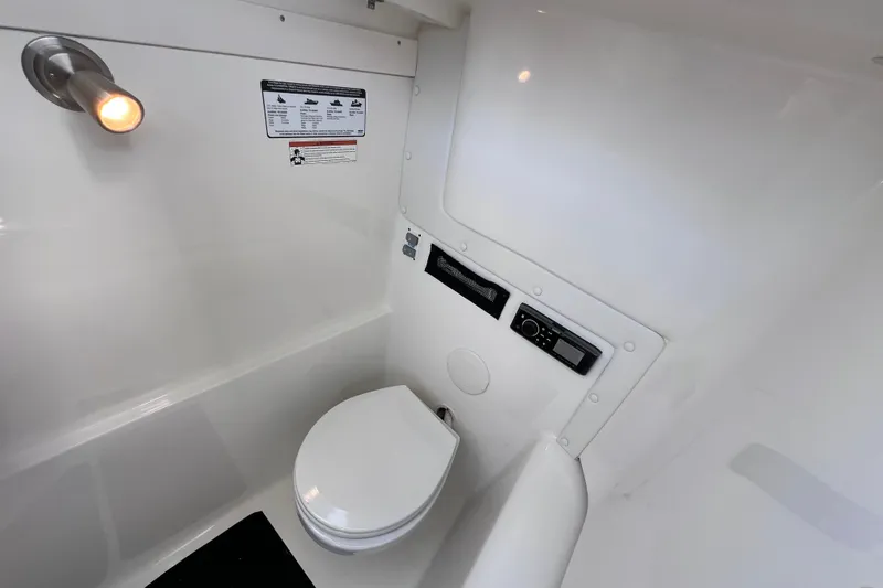 Slide: The Image of 2019 World Cat 255 DC boat interior with compact marine toilet and control panel. - 80