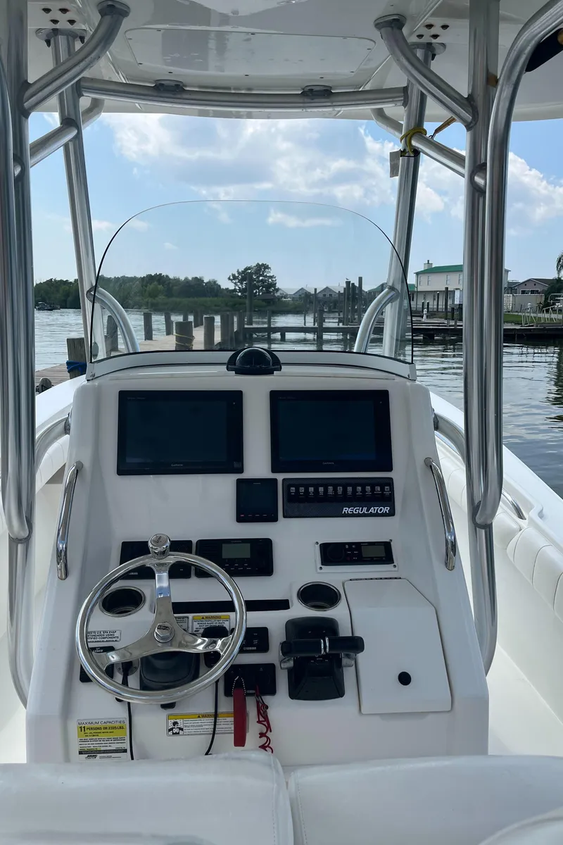 Slide: The Image of 2015 Regulator 25 boat console with steering wheel and navigation screens. - 2