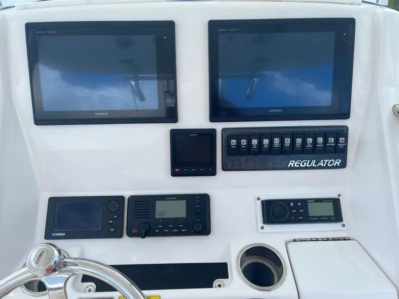 Slide: The Image of 2015 Regulator 25 boat dashboard with dual Garmin displays and control panel. - 3