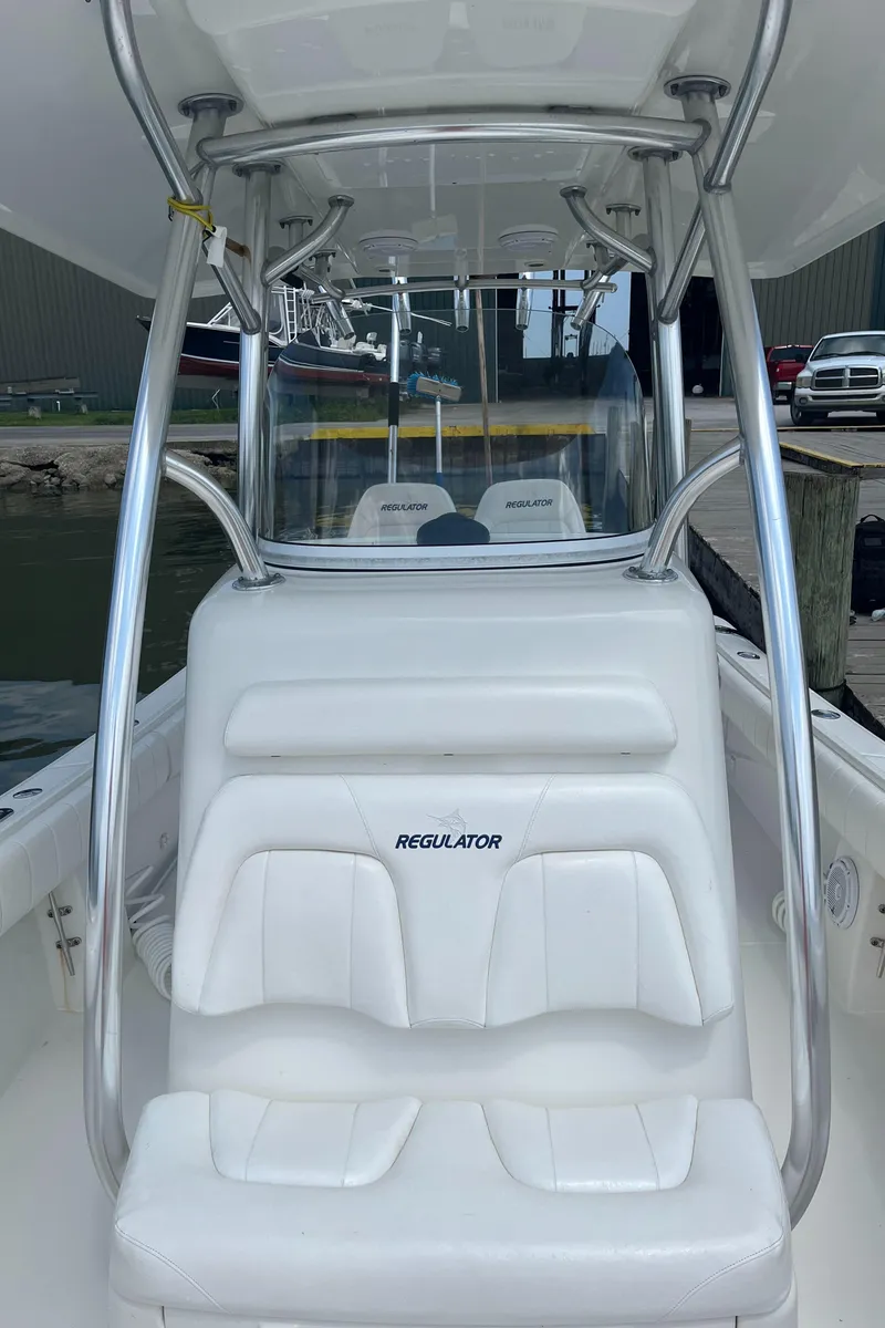 Slide: The Image of 2015 Regulator 25 boat with white seating and T-top frame. - 5