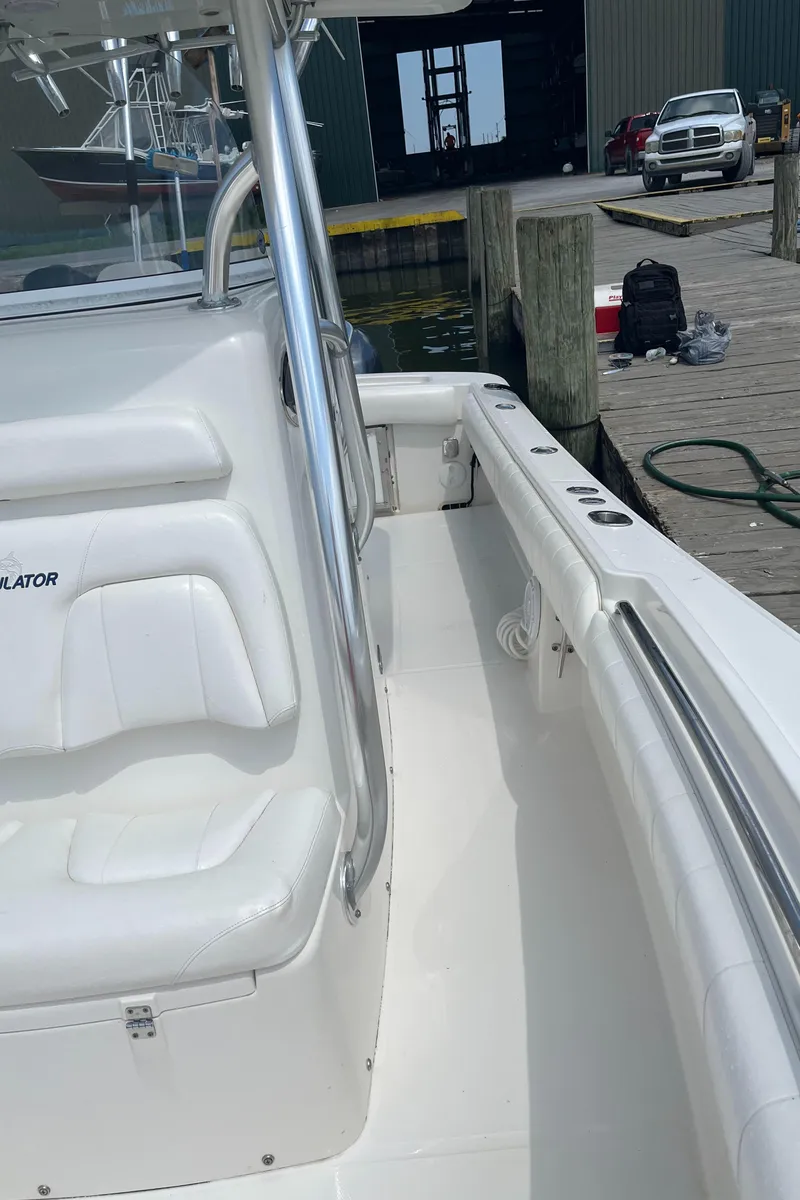Slide: The Image of 2015 Regulator 25 boat docked at a marina, showcasing its clean white interior. - 6