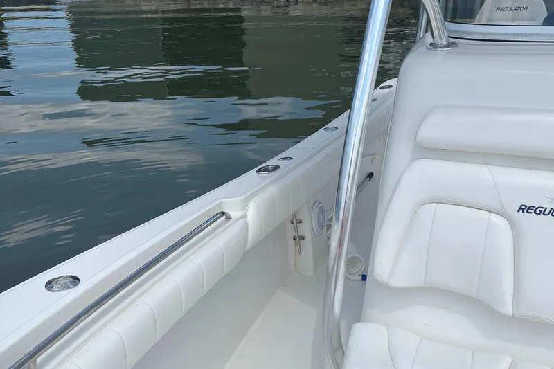 Slide: The Image of 2015 Regulator 25 boat interior with white seating and stainless steel railings. - 7