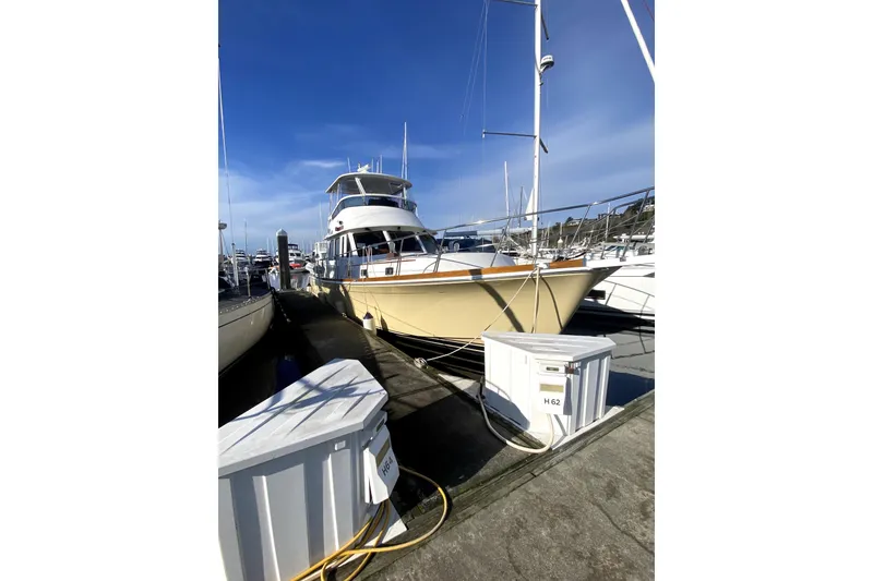 Slide: The Image of 2007 Grand Banks 47 East Bay yacht docked at marina under clear blue sky. - 76