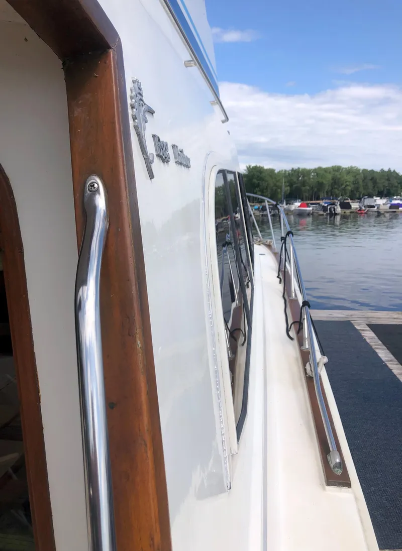 Slide: The Image of Egg Harbor Convertible 37, 1987 model, docked by the lakeside. - 11