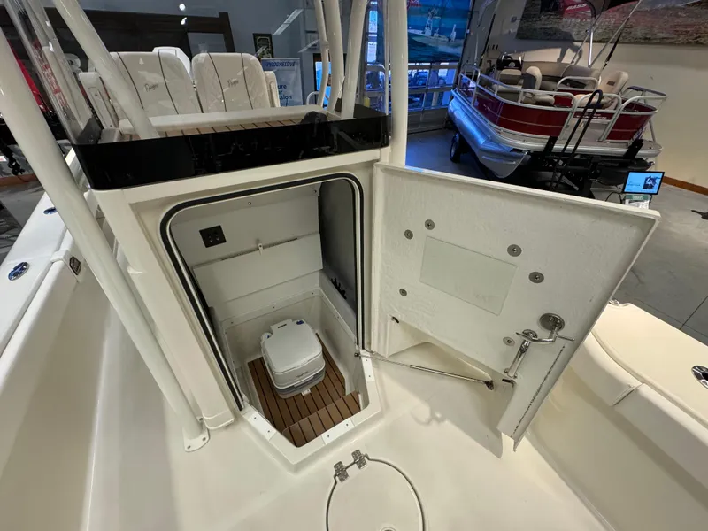 Slide: The Image of 2024 Ranger 2600 Bay boat interior with open compartment and portable toilet. - 10