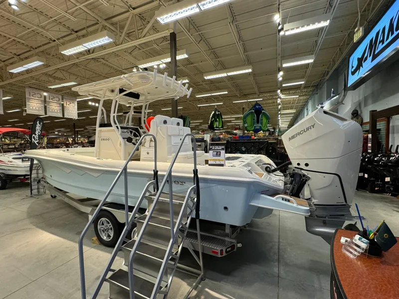 Slide: The Image of 2024 Ranger 2600 Bay boat on display in a showroom with a Mercury outboard motor. - 3