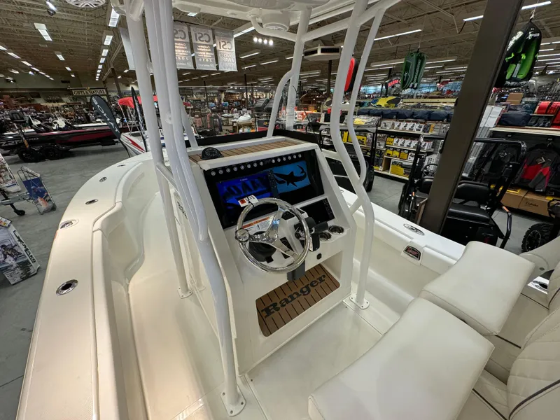 Slide: The Image of 2024 Ranger 2600 Bay boat interior with steering console and seating in showroom. - 7