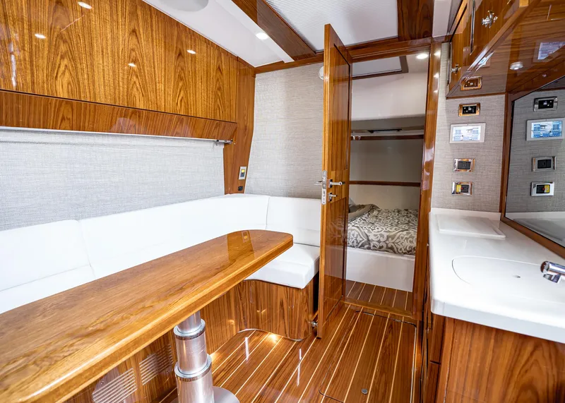 Slide: The Image of Luxurious 2021 HCB Estrella yacht interior with wood finishes, white seating, and cozy bedroom. - 29