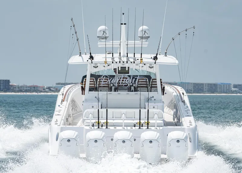 Slide: The Image of 2021 HCB Estrella boat cruising on the water with fishing rods and cityscape in the background. - 6