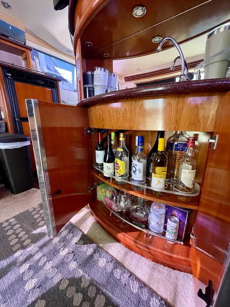 Slide: The Image of Bar area inside a 2000 Carver 45 Voyager yacht with stocked liquor cabinet. - 10