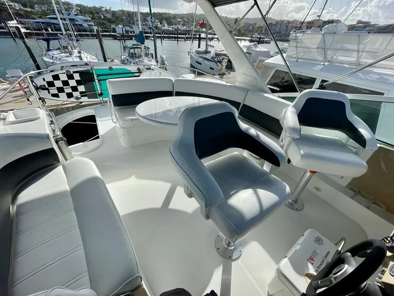 Slide: The Image of 2000 Carver 45 Voyager yacht interior with seating and table, docked at marina. - 5