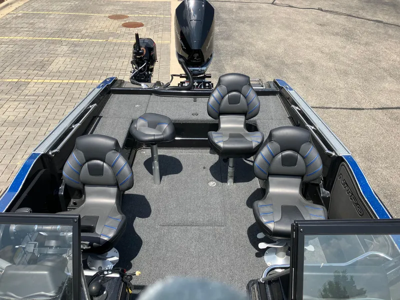 Slide: The Image of 2024 Nitro ZV20 Pro boat interior with four seats and motor, parked on pavement. - 8