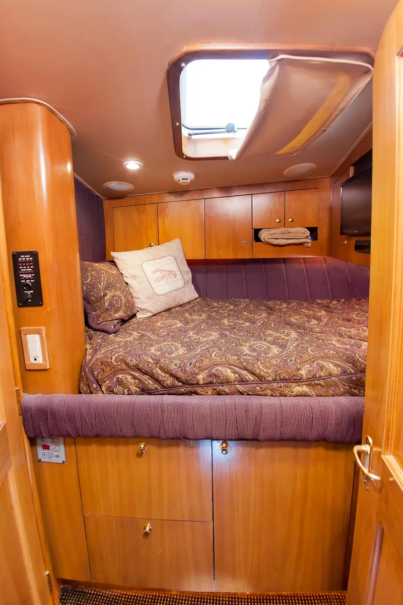 Slide: The Image of Cozy cabin interior of 2000 Buddy Davis 78 yacht with wood paneling and plush bedding. - 12