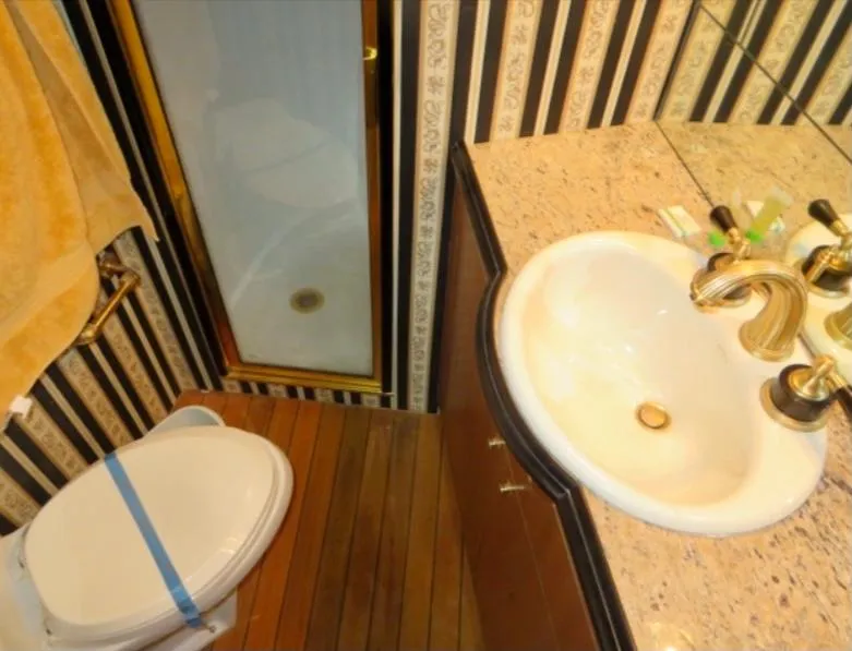 Slide: The Image of Luxury yacht bathroom with striped wallpaper, wooden floor, and elegant fixtures. Buddy Davis 78, 2000 model. - 26