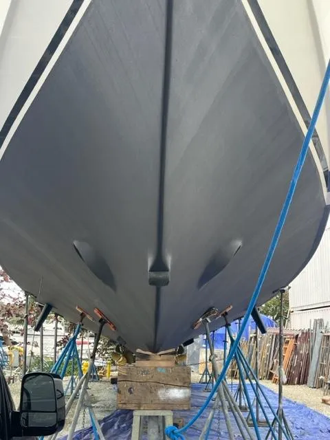 Slide: The Image of Bottom view of a 2000 Buddy Davis 78 boat on stands in a shipyard. - 37