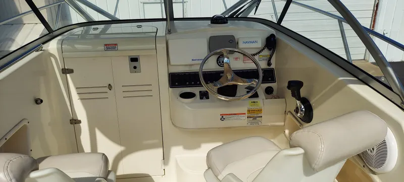 Slide: The Image of 2006 Boston Whaler 235 Conquest boat cockpit with steering wheel and seating. - 5