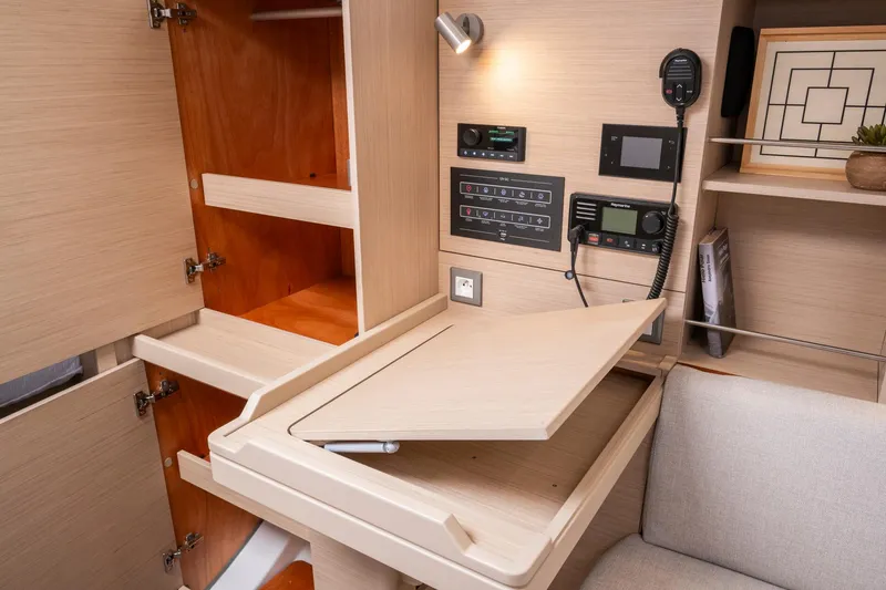 Slide: The Image of 2024 Beneteau Oceanis 37.1 interior navigation station with storage cabinets and control panels. - 19