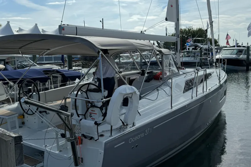 Slide: The Image of 2024 Beneteau Oceanis 37.1 sailboat docked at marina, showcasing sleek design and modern features. - 2