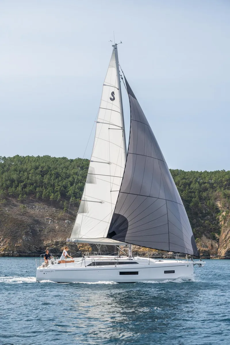 Slide: The Image of 2024 Beneteau Oceanis 37.1 sailing on a serene coastal waterway. - 4