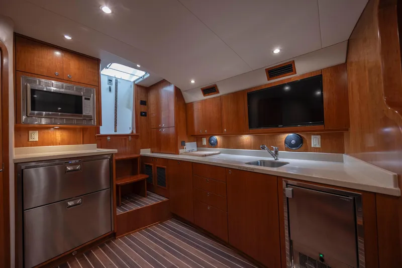 Slide: The Image of 2019 Albemarle 410 Express Fisherman yacht kitchen with modern appliances and wooden cabinetry. - 27