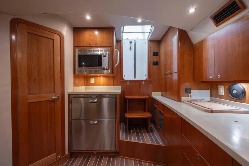 Slide: The Image of 2019 Albemarle 410 Express Fisherman kitchen with wood cabinetry and stainless steel appliances. - 28