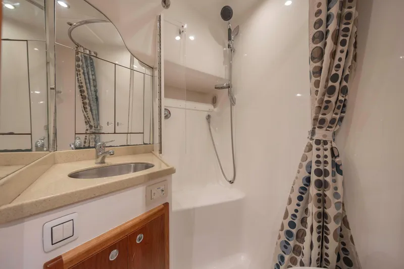 Slide: The Image of 2019 Albemarle 410 Express Fisherman bathroom with shower, sink, and polka dot curtain. - 30