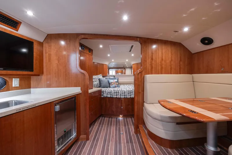 Slide: The Image of 2019 Albemarle 410 Express Fisherman interior with wood finishes and cozy seating area. - 36