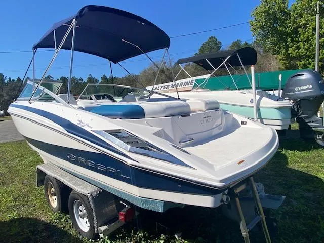 Slide: The Image of 2012 Regal 2100 boat on trailer with blue canopy in outdoor setting. - 4
