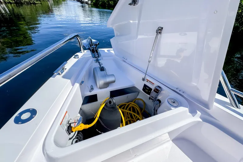 Slide: The Image of 2024 Axopar 37 Sun Top boat storage compartment with equipment and yellow hose. - 28